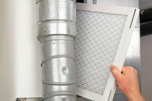 Hand removing an air filter from an HVAC system, highlighting air quality improvement during home renovations.