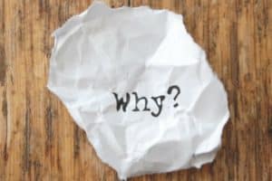 Crumpled paper with the word "Why?" on a wooden surface, symbolizing inquiries about air quality and the importance of duct cleaning.