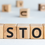 Wooden blocks spelling "STOP" on a light surface, highlighting HVAC and home improvement themes from The Meridian Company.