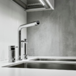 Modern kitchen faucet and sink with sleek chrome finish, featuring The Meridian Company's home improvement services.