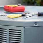Air conditioning repair tools: red toolbox, yellow pliers, and screwdriver from The Meridian Company.