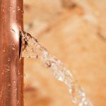 Copper pipe leaking water, illustrating a potential plumbing issue relevant to water leak detection and repair services.
